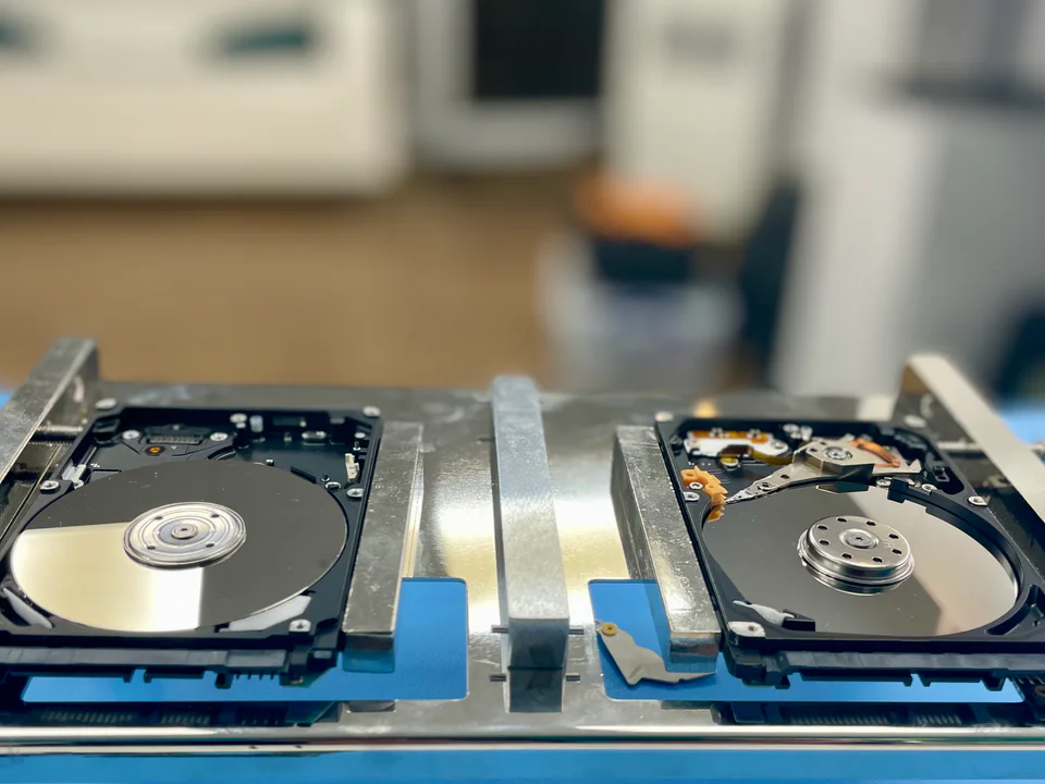 Two open hard drives secured for data recovery work
