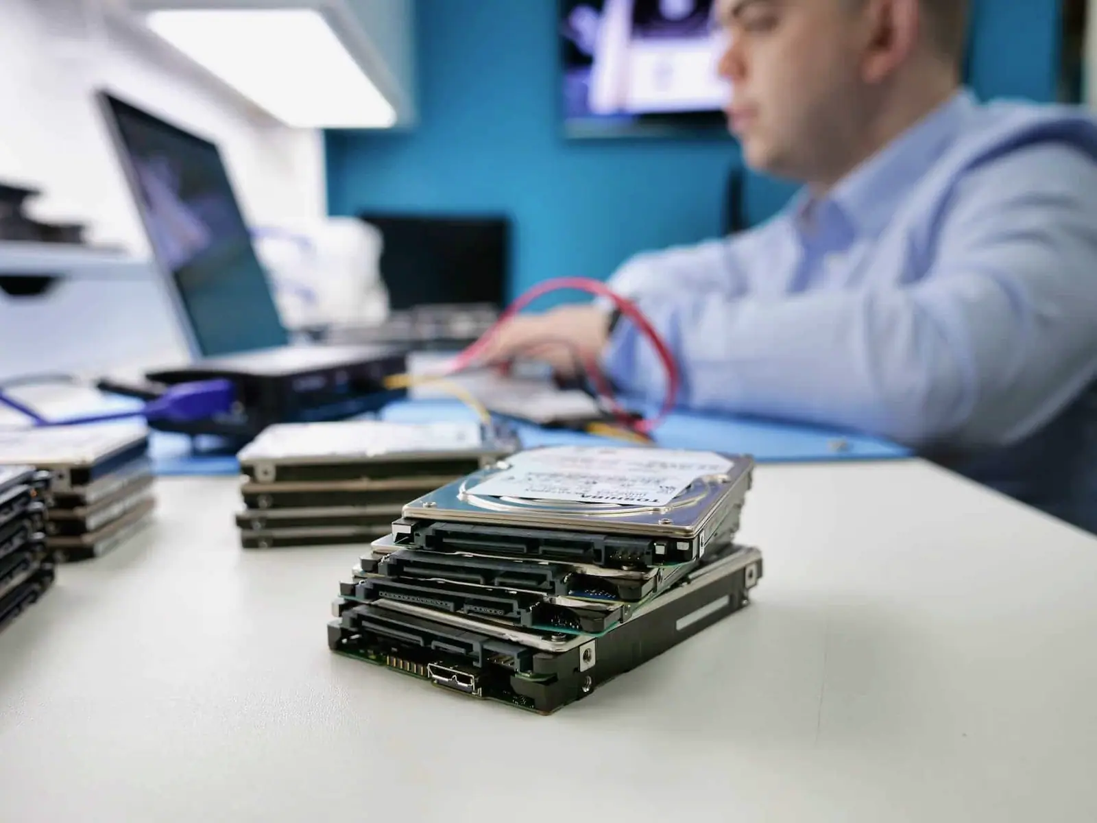 A stack of hard drives on the bench, kept as donors for parts matching